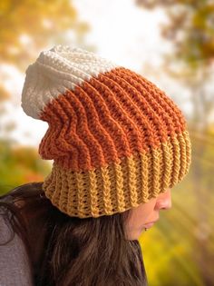 a woman wearing an orange and white knitted hat