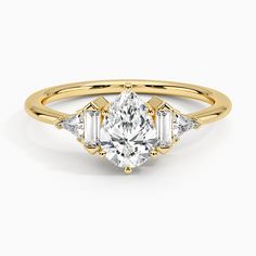 a yellow gold engagement ring with an oval cut diamond and three baguets on the side