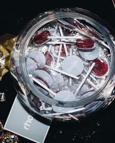 a glass bowl filled with lots of candies and lollipops on top of a table