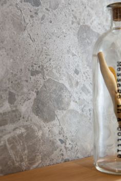 a wooden stick in a glass bottle on a table