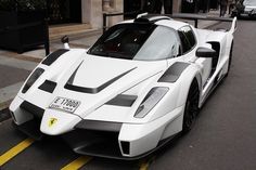 a white sports car is parked on the street