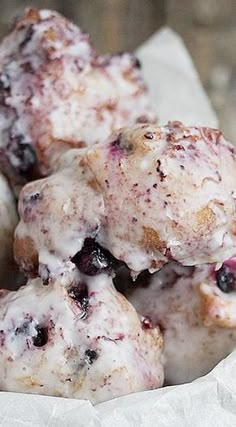 blueberry donuts with icing and sprinkles in a paper bag