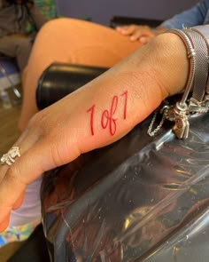 a woman's arm with the number 1011 on it and her hand in red ink