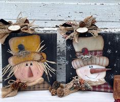 two wooden plaques decorated with scarecrows and pine cones