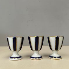 three black and white cups sitting next to each other