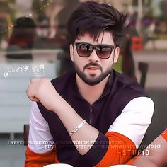 a man wearing sunglasses sitting at a table with two cups of coffee in front of him