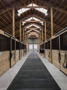 the inside of a barn with horses in stalls