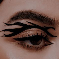 a woman's eye with black and white lines painted on the upper part of her eyelashes