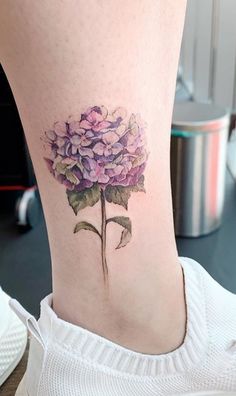 a woman's lower leg with a flower tattoo on her left side ribcage