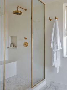 a bathroom with white walls and gold fixtures