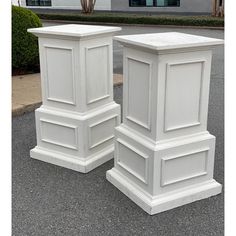 two white pedestals sitting in the middle of a parking lot