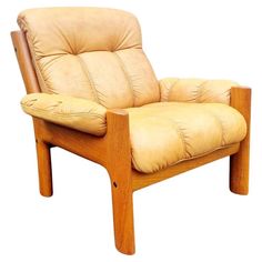 a tan leather chair with wooden legs and arm rests against a white background, it appears to be made of wood