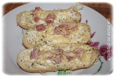 two pieces of bread with ham and cheese on them are sitting on a floral plate