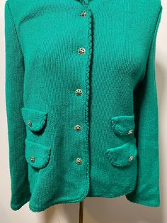 This 1960's Butte cardigan is the cutest! It is an acrylic and cotton blend and closest to a size medium. Here are the exact measurements taken lying flat and doubled: Shoulders: 15 inches Chest: 36 inches Waist: 36 1/2 inches Shoulders to Hem: 22 inches This sweater cardigan has a rounded collar and golden, flower shaped buttons going up the front. There are also snaps on the inner part of this sweater, but no connectors for them to snap into, the only flaw I have noted. This cardigan has four, Vintage Knit Outerwear With Button Closure, Vintage Knit Outerwear With Buttons, Vintage Green Cardigan With Button Closure, Green Vintage Cardigan With Buttons, Retro Knit Sweater With Buttons, Vintage Green Knit Outerwear, Vintage Green Knit Sweater, Vintage Green Knit Cardigan, Green Vintage Knit Cardigan