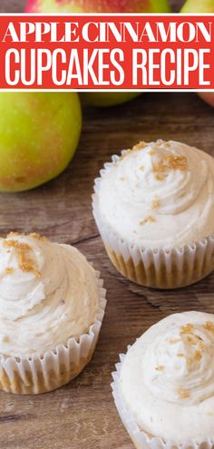 three cupcakes with white frosting and apples in the background