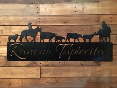 a metal sign that says rancheria tapiceta with horses and cowboys on it