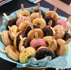 a bowl filled with donuts covered in frosting and sprinkles sitting on top of a table