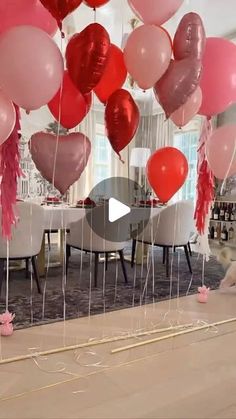 a room filled with lots of pink and red balloons