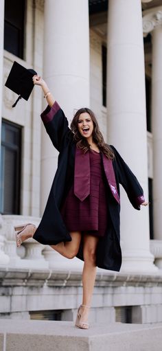 a woman in a graduation gown and cap is posing on steps with her arms up