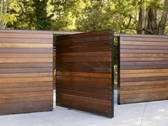 an open wooden door on the side of a building with trees in the back ground