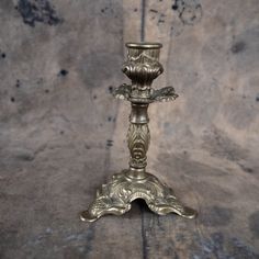 an ornate metal candle holder on a wooden table