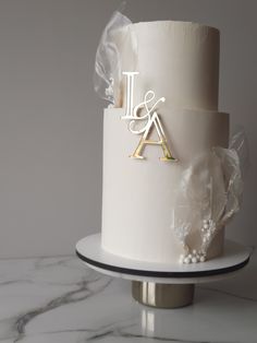 a white wedding cake with the initials on it