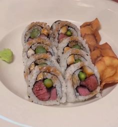 a white plate topped with sushi and chips