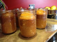 four jars filled with food sitting on top of a counter