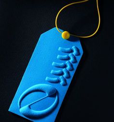 a blue name tag with a yellow string attached to it on a black table top