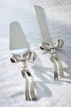 pair of silver earrings with bows on white cloth