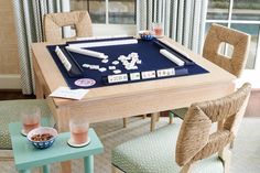 a dining room table with two chairs and a board game set up in front of it