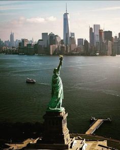 the statue of liberty stands in front of new york city