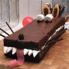 a chocolate cake with white and black icing on it's face, decorated with toothbrushes