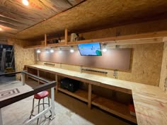 a room with some shelves and lights on the ceiling, and two stools in front of it