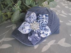 ALL ORDERS TOTALING OVER $35 SHIP FREE I designed this blue navy  trucker baseball cap making an adorable coordinating fabric petal flower. I added a beautiful all rhinestone accent to the center of the flower.  This hat is so pretty. See more of my  hats here: http://www.etsy.com/shop/theraggedyrose?section_id=10557807 CUSTOM ORDERS ALWAYS WELCOME.... Will ship in 1 to 2 business days after payment is received.  Thanks for taking the time to stop by and look at my little shop. Hope you enjoyed. Bling Hats, Painted Hats, Summer Hats For Women, Flower Hat, Hats Baseball, Petal Flower, Cap Designs, Fabric Roses, Hat Summer