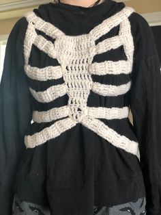 a woman wearing a black shirt with a white knitted skeleton on it's back