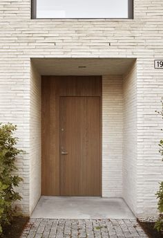 an entrance to a white brick building with a wooden door