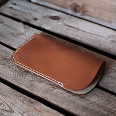 a leather wallet sitting on top of a wooden bench