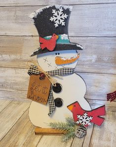 a snowman made out of wood with a sign attached to it's head