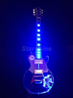 an electric guitar lit up in the dark with blue lights on it's neck