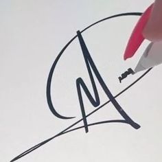 a person writing on paper with a marker and pen in their hand, next to the letter m