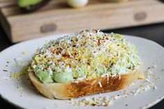 a close up of a piece of bread on a plate with sprinkled toppings