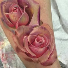 a pink rose tattoo on the arm