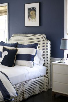 a bedroom with blue walls and white bedding