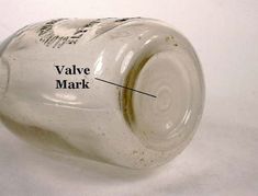 an empty glass bottle labeled with the name valve mark on it's bottom side