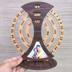 a person holding up a wooden trophy with an image on it's front and sides