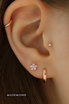 a close up of a person's ear with three different piercings on it