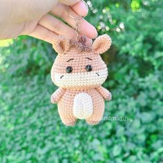 a small crocheted animal keychain hanging from a person's hand