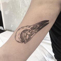 a woman's arm with a black and white drawing of a bird on it