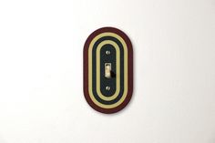 a light switch cover with an oval design on the wall in front of a white background